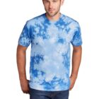 Man in blue tie-dye shirt and jeans standing against a white background.