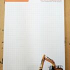 Grid notepad with Orange Hire logo and an excavator image at the bottom right corner.