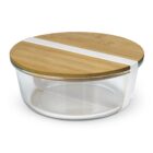 A glass storage container with a round, flat bamboo lid. The container has a white silicone band wrapped around it for secure sealing. The lid and band add a natural and modern touch to the design.