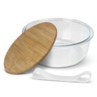 A round glass container with a wooden lid is shown partially open. A white silicone band is placed in the foreground. The container is empty and the background is plain white.