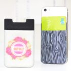 A smartphone with a back pocket holds a green card displaying the word myki.” Next to it is a separate cardholder with a floral design labeled Smart Wallet. Both items are placed on a white surface.