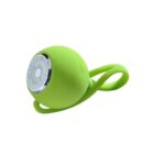 A small, round, green portable speaker with a loop handle. The speaker has a silver grille and a smooth, matte finish.