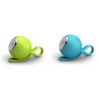 Two spherical portable speakers, one green and one blue, each with a looped handle. They have a metallic speaker grill on the front. The design is sleek and modern, displayed on a white background.