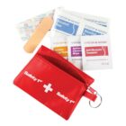Red first aid pouch with bandage, wipes, alcohol pads, and a keyring attached.