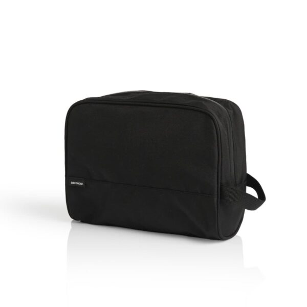 A black toiletry bag with a rectangular shape, featuring a subtle stitched logo near the bottom left corner. The bag has a side handle, and its surface has a smooth, slightly textured appearance. The background is a clean, solid white.