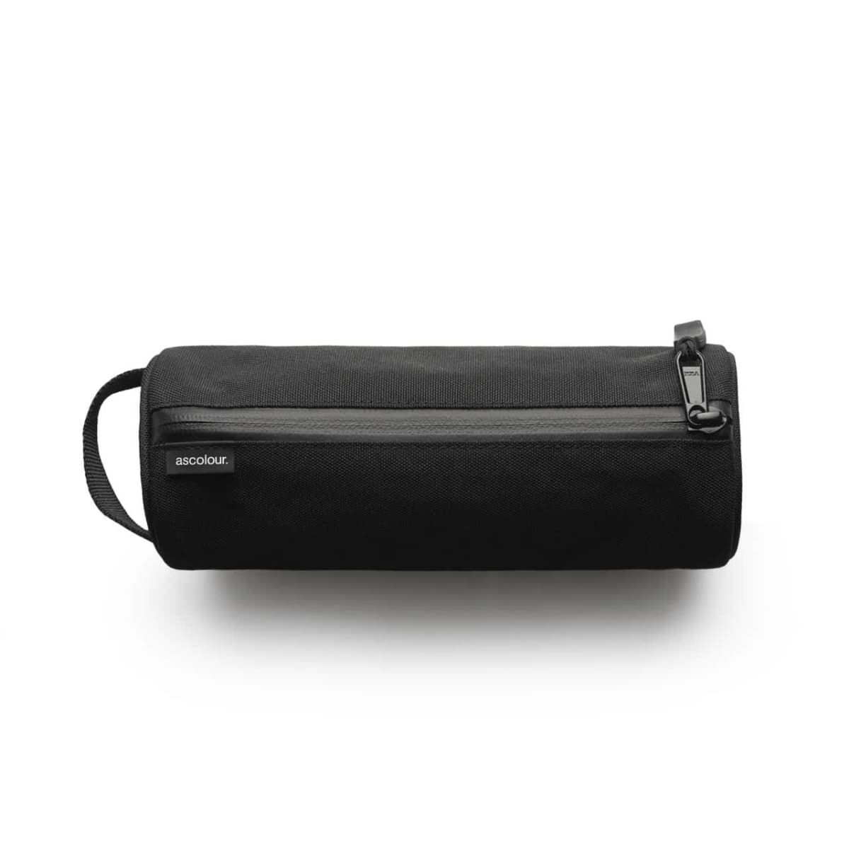 Black cylindrical toiletry bag with a zipper and a small handle on one side. The brand label ascolour is visible on the side of the bag. The bag is placed against a neutral white background.