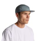 Man wearing a light blue cap and a plain white t-shirt, looking to the side. The background is plain white.