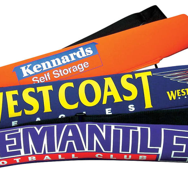 Three sports-themed pool noodles are stacked. The top is orange with Kennards Self Storage, the middle is blue with West Coast Eagles, and the bottom is purple with Fremantle Football Club.