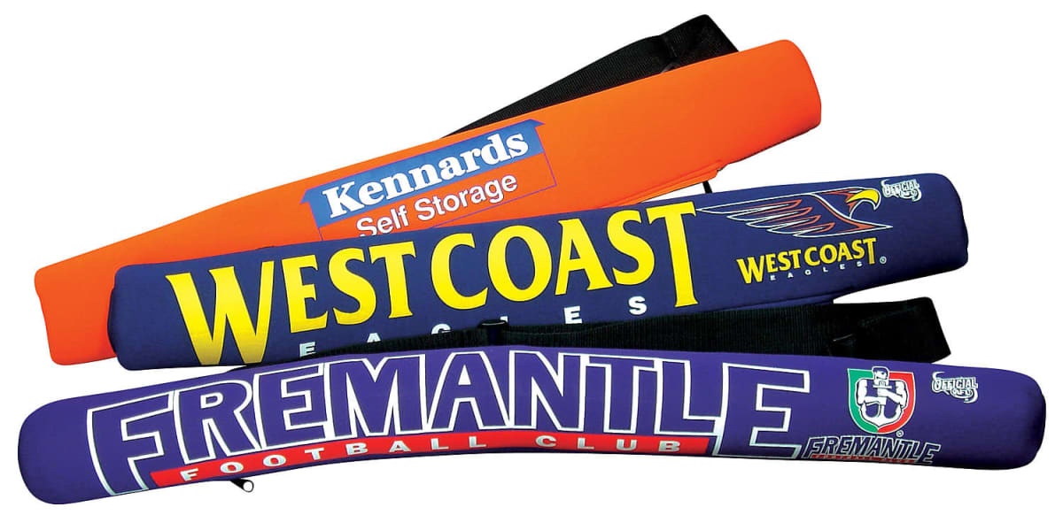 Three sports-themed pool noodles are stacked. The top is orange with Kennards Self Storage, the middle is blue with West Coast Eagles, and the bottom is purple with Fremantle Football Club.