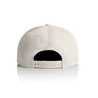 A plain cream-colored baseball cap shown from the back, with an adjustable snap closure and six-panel construction, is reflected on a white surface.