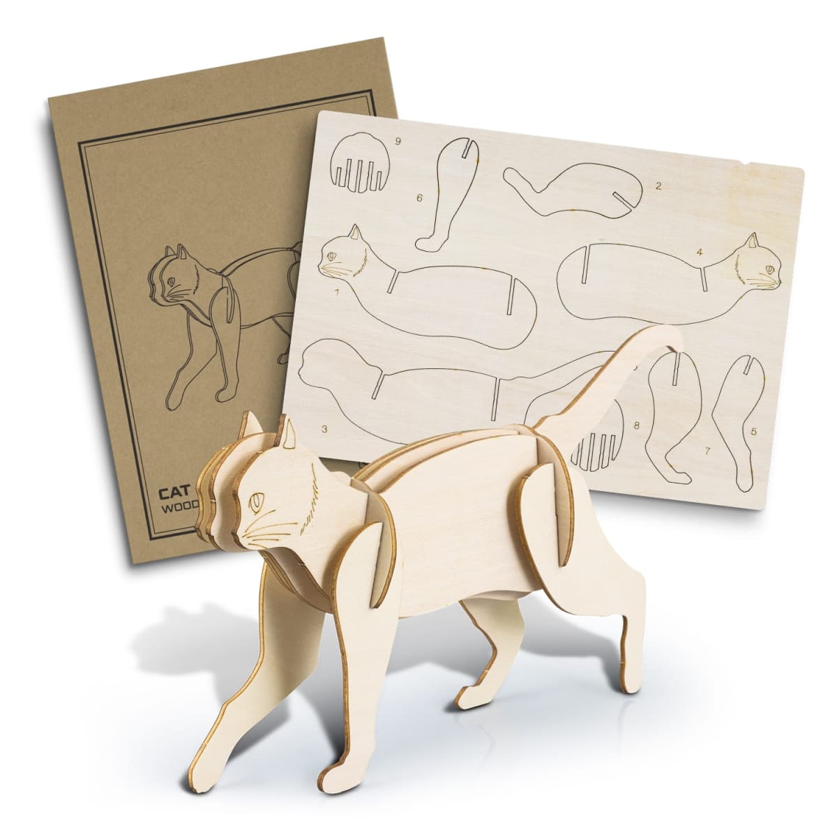 A wooden cat model kit with pre-cut pieces displayed alongside an instructional sheet. The assembled model shows a standing cat, with numbered parts visible on the unassembled sheet. A brown instruction booklet lies underneath.