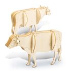 Two wooden cow models are shown, made from interlocking flat pieces. The design includes cut-out patterns that resemble the contours and features of real cows. The models are identical, positioned with one slightly behind the other.