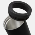 A close-up image of a black stainless steel travel mug with its lid partially unscrewed and open, showing the shiny silver interior. The mug is positioned against a plain light gray background.