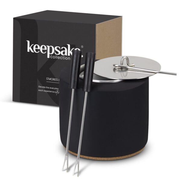 A black cylindrical container labeled keepsake collection with a metal lid and handle. Two metal skewers with black handles are leaning against it. A black and brown box is in the background.