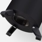A close-up of the bottom of a black, cylindrical object with three evenly spaced, folded legs. The legs have ribbed grips at their ends and are attached to a circular base. The background is plain white.