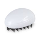 A white, oval-shaped hairbrush with black bristles is lying on a plain white surface.