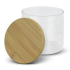 Clear glass jar with a cylindrical shape and an open top, accompanied by a flat, round wooden lid made of bamboo, resting on its side. The jar is empty and both items are set against a plain white background.