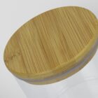 Close-up of a glass jar with a smooth, round bamboo lid. The lid features a natural wood grain pattern, while the jar itself is transparent, revealing its empty interior. The background is a plain, light color.