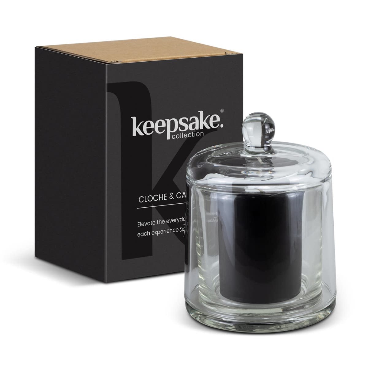 A black candle in a clear glass holder with a lid, placed next to a black box labeled keepsake collection. The box has a brown top and text detailing the products features.