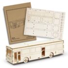 A wooden bus model kit with laser-cut parts for assembly. The image shows a partially assembled bus along with the sheets containing the unassembled pieces and an instruction booklet.