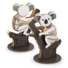 Two wooden koala puzzles perched on tree branch bases. Each koala features detailed cutouts for a layered, 3D effect and is designed in natural wood tones with gray and white accents.