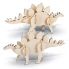 Two wooden dinosaur models resembling Stegosaurus, each with plates along their backs and spiked tails. The models are assembled from interlocking pieces and positioned side by side on a white background.