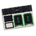 A metal sheet with black and green cutouts featuring sections resembling arcades and rectangles. Two sections display a plant growing from money symbols, outlined in green.