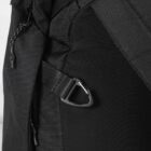 Close-up of a black backpack featuring a sturdy strap and carabiner clip with a textured fabric. The design includes a braided cord tied to a zipper, adding to its rugged and functional appearance.