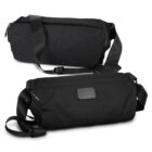 Two black sling bags with adjustable straps are displayed against a white background. One bag shows the front, featuring a sleek design, while the other shows the back, highlighting a rectangular patch. Both have a minimalist, modern style.