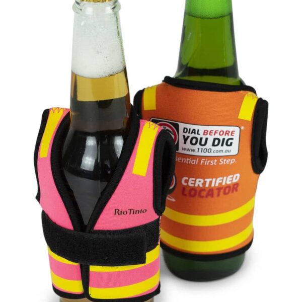 Two beer bottles wearing small safety vests. One vest is bright orange with a Certified Locator label, and the other is pink and yellow. The vests mimic construction safety gear.