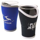 Two glass cups wrapped in differently colored neoprene sleeves. The left sleeve is blue with a white design, and the right sleeve is black with white lettering. The sleeves provide insulation and grip.