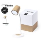 A sleek, modern desk lamp with a cork shade and white base that features a wireless charging pad. The lamp is displayed beside a matching white and cork box labeled Limited Edition and Premium Gift 4K.