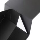 Close-up of a black triangular box with a contrasting white triangular tab visible on the side. The box appears open, showing the interior with sharp, clean lines and a modern design.