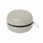 A beige yo-yo with a speckled texture, featuring a white string attached to one side, against a plain white background.