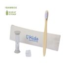 A bamboo toothbrush with soft bristles, a small sand timer, and a dental tray are displayed next to a beige pouch labeled Kids Dentistry. The pouch is made of wheat straw, as indicated by the icons and text at the top left.
