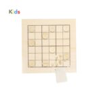 A wooden tic-tac-toe board with engraved symbols on square tiles, placed on a grid. Some tiles are marked, and there is a small fabric bag beside the board. The word Kids is written in colorful letters at the top.