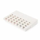 A white rectangular object with circular holes on its surface, resembling a plastic cover or casing.