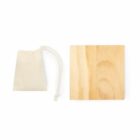 A small beige drawstring pouch is placed next to a square piece of light-colored wood. The background is plain white.