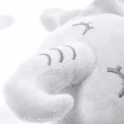 Close-up of a plush, light gray elephant toy with a soft, fuzzy texture. The toys stitched eyes are closed, and its trunk is curved upward. The background is a soft white, giving a cozy and gentle appearance.