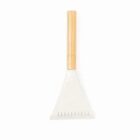 A bamboo-handled brush with a wide, triangular white bristle head on a white background.