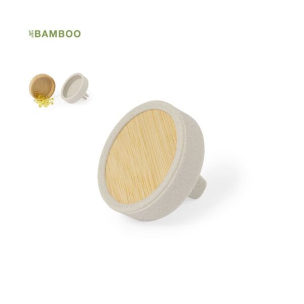 A round bamboo badge with a natural wood finish and a white border. Another badge filled with small, yellow candies is visible in the background. A green BAMBOO logo is in the top left corner.
