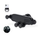 A black car phone holder with a gravity design, featuring four adjustable clamps. An inset shows the holder attached to a cars air vent, securely holding a smartphone.