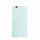 A light green, rectangular gym towel with a textured surface hangs on a white hook. A small black tag with branding details is visible at the top corner. The background is plain white.