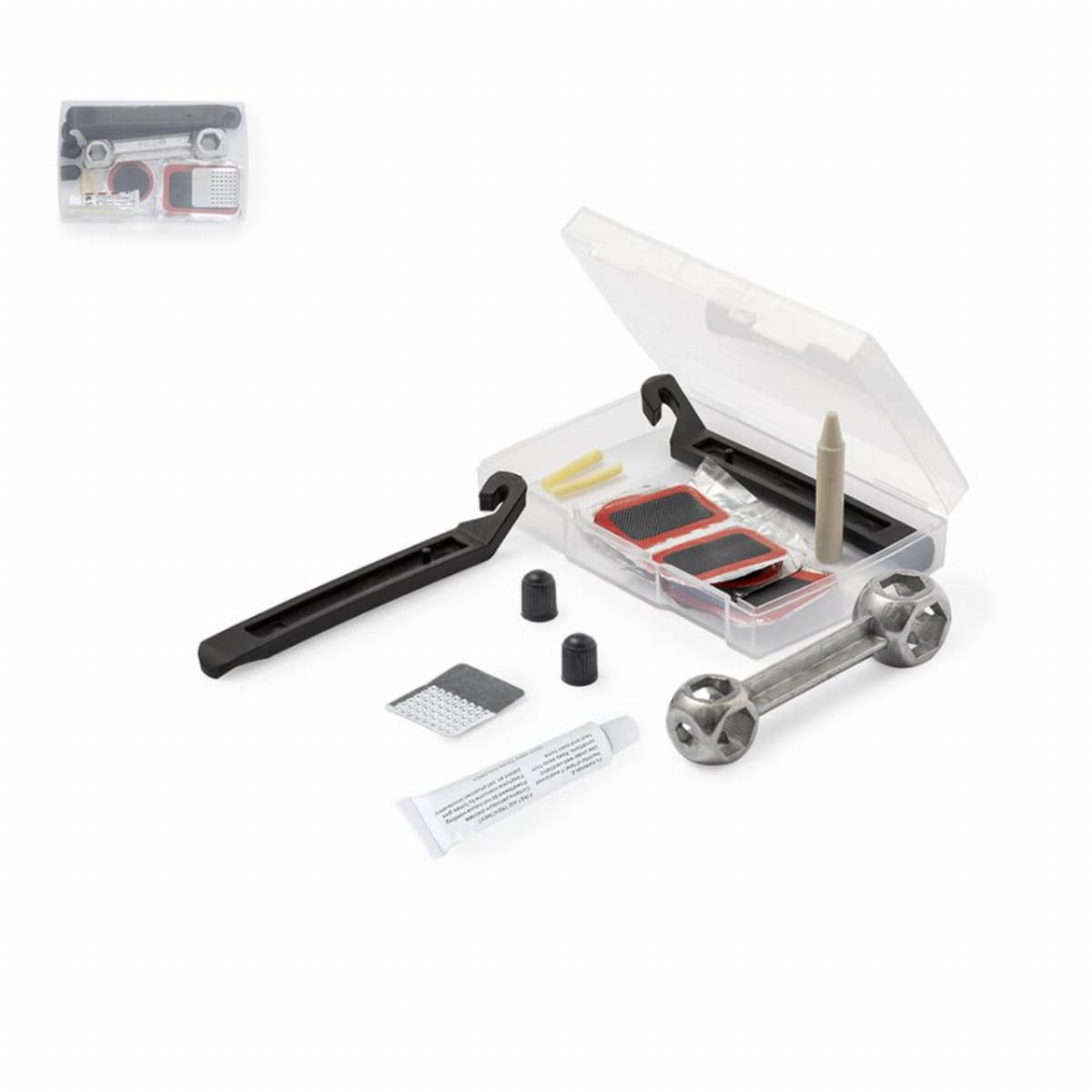 A bicycle repair kit displayed on a white background. It includes tire levers, patches, a metal multi-tool, rubber solution in a tube, sandpaper, and small cylinder caps. The items are arranged around an open plastic box.