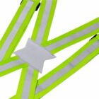 Close-up of a reflective safety vest with bright green and white stripes. The vest has a crisscross design and a rectangular patch at the center, designed for visibility and safety.