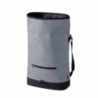 A tall, cylindrical gray duffel bag with a black base and trim. It features a front zipper pocket and an adjustable shoulder strap on the right side. The bag has a sleek, simple design.