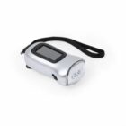 A silver hand-crank flashlight with a black strap. It has a transparent cover over the LED bulbs and a small black crank handle on the side. A solar panel is visible on the top surface.