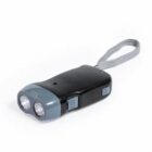 A small, black hand-crank flashlight with two round LED bulbs at the front. It has a gray accent around the bulbs and a gray wrist strap attached to the end.