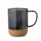 A glass mug with a cork base and a handle, set against a plain white background.