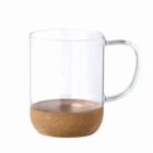 Clear glass mug with a cork base, isolated on a white background.